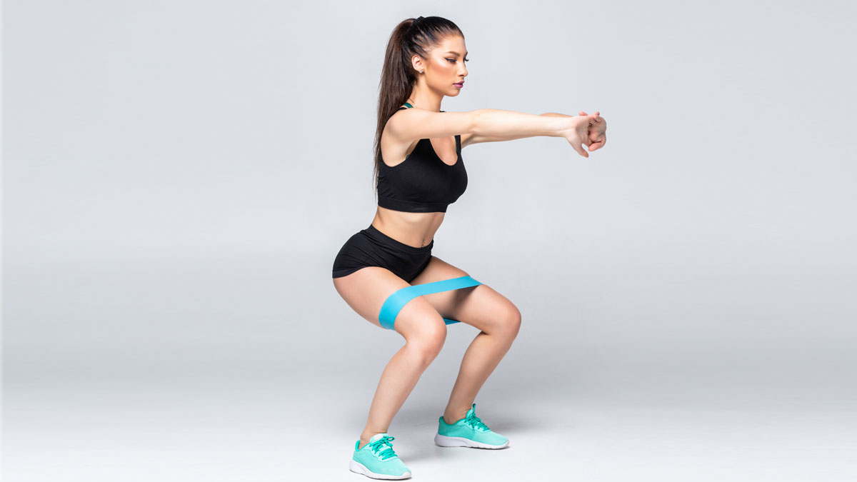 woman doing a modified squat using resistance band