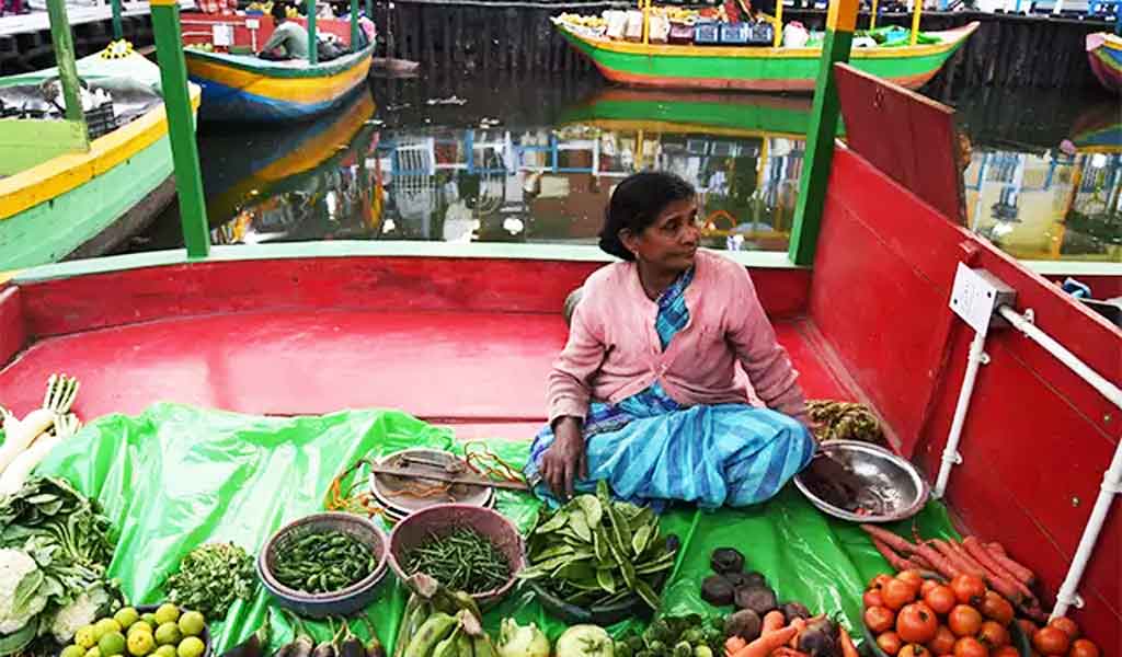 একজম মহিলা সবজি বিক্রি করছেন 