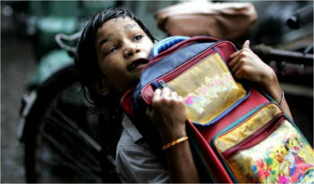 स्कूल के भारी बस्ते के साथ एक विद्यार्थी 