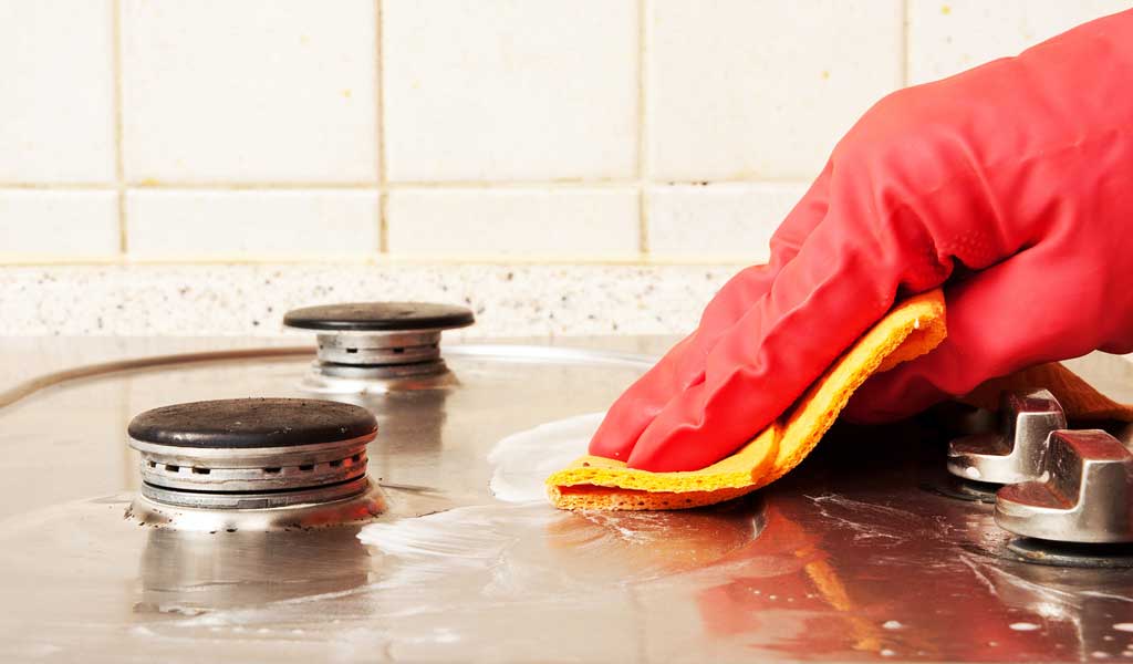 গ্যাস ওভেন পরিষ্কার করছে 