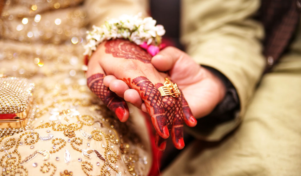 নব দম্পতি হাত ধরে বসে আছে