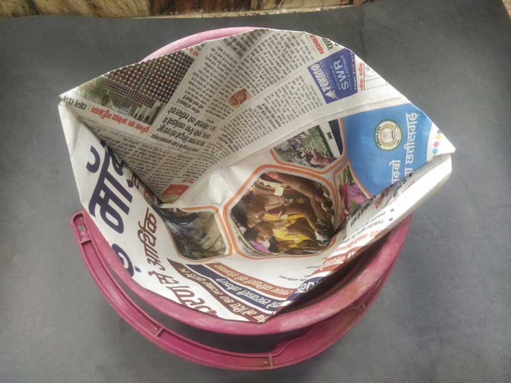 Newspaper dustbin bag in bucket
