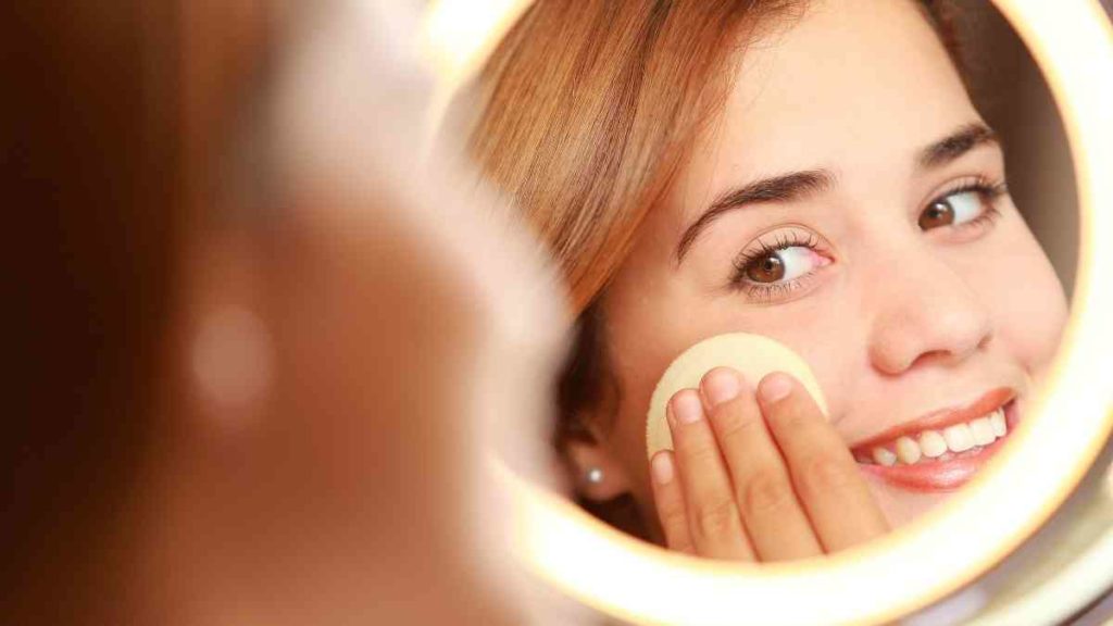 woman applying powder to her face