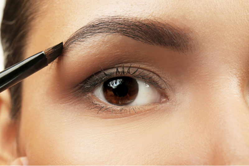 Indian woman doing her eyebrows